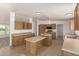 Open kitchen area features wood cabinetry, stainless appliances, and a double kitchen island at 13217 S Tuthill Rd, Buckeye, AZ 85326