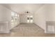 Open concept living room with neutral colored carpet and an array of windows allowing for ample natural light at 13217 S Tuthill Rd, Buckeye, AZ 85326