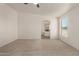 Bright main bedroom featuring neutral carpeting and an archway to the bathroom at 13217 S Tuthill Rd, Buckeye, AZ 85326