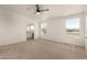 Bright main bedroom features a ceiling fan, carpeting and an archway to the bathroom at 13217 S Tuthill Rd, Buckeye, AZ 85326