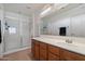 Bright bathroom with glass enclosed shower, a wooden vanity and a large mirror at 1350 S Greenfield Rd # 2133, Mesa, AZ 85206