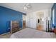Inviting bedroom with blue accent wall, light carpet, dresser and ensuite bathroom at 1350 S Greenfield Rd # 2133, Mesa, AZ 85206