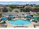 Community pool with lounge chairs, umbrellas, and mountain views in the background at 1350 S Greenfield Rd # 2133, Mesa, AZ 85206