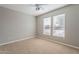 Neutral bedroom showcasing wall-to-wall carpet, standard ceiling fan, and double windows at 15936 W Kino Dr, Surprise, AZ 85374
