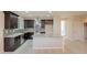 Modern kitchen with dark wood cabinets, granite countertops, and stainless steel appliances at 15936 W Kino Dr, Surprise, AZ 85374