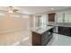 Kitchen island with granite countertop, dark cabinetry, and stainless steel microwave at 15936 W Kino Dr, Surprise, AZ 85374