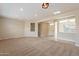 Open-concept living room with neutral walls, carpet, and view to front entrance at 15936 W Kino Dr, Surprise, AZ 85374