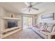 Comfortable living room with a plush sofa, ceiling fan, built-in shelving, and access to a private balcony at 16631 E El Lago Blvd # 208, Fountain Hills, AZ 85268