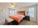Inviting main bedroom with a ceiling fan, windows, a wooden bed frame, and an ottoman at 16631 E El Lago Blvd # 208, Fountain Hills, AZ 85268