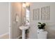 Powder room with pedestal sink, decorative mirror, and patterned floor tiles at 17183 W San Marcos St, Surprise, AZ 85388