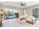 Bright living room featuring tile floors, modern ceiling fan, and sliding glass doors to the backyard at 17183 W San Marcos St, Surprise, AZ 85388