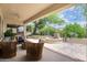 Inviting covered patio overlooking a beautiful backyard garden with a fountain and lush greenery at 19803 N Desert Song Ct, Surprise, AZ 85374