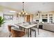 Elegant dining area with a marble table, stylish chairs, chandelier, and views into the living room at 19803 N Desert Song Ct, Surprise, AZ 85374