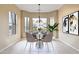 Bright dining area with a chandelier, table with seating, and views of the surrounding desert landscaping at 19803 N Desert Song Ct, Surprise, AZ 85374