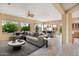 Open-concept living area featuring tile floors, ceiling fan, a comfortable gray couch, and a dining area at 19803 N Desert Song Ct, Surprise, AZ 85374