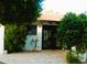 Back patio entrance featuring mature landscaping and neutral pavers creates a relaxing outdoor retreat at 2068 E Cairo Dr, Tempe, AZ 85282