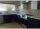 Updated kitchen boasts stainless appliances, white cabinets, quartz counters and eye-catching backsplash at 2068 E Cairo Dr, Tempe, AZ 85282