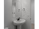 Bathroom featuring a pedestal sink, wall mirror, and lighting fixtures at 21541 W Mariposa St, Buckeye, AZ 85396