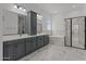 Modern bathroom featuring double sinks, a soaking tub, and a glass-enclosed shower at 21541 W Mariposa St, Buckeye, AZ 85396