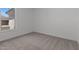 A bright bedroom with neutral carpet and a view from a large window at 21541 W Mariposa St, Buckeye, AZ 85396