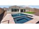 A beautiful backyard pool and spa with travertine tile decking create an oasis for outdoor living and entertaining at 21541 W Mariposa St, Buckeye, AZ 85396