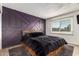 Bedroom featuring a purple accent wall, plush bed, natural light, and light-colored flooring at 2423 E Dahlia Dr, Phoenix, AZ 85032