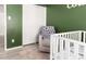 Cozy Bedroom with green walls, white closet, gray recliner, and white crib at 2423 E Dahlia Dr, Phoenix, AZ 85032