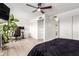 Bedroom featuring a ceiling fan, walk-in closet, desk area, and light-colored flooring at 2423 E Dahlia Dr, Phoenix, AZ 85032