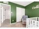 Cozy green bedroom featuring a crib, soft rug, and closet with sliding doors at 2423 E Dahlia Dr, Phoenix, AZ 85032