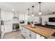 Modern kitchen boasts a wood island, white cabinets, black hardware, and stainless steel appliances at 2423 E Dahlia Dr, Phoenix, AZ 85032