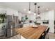 Kitchen features white cabinets, stainless steel appliances, butcher block island, and stylish pendant lighting at 2423 E Dahlia Dr, Phoenix, AZ 85032