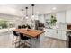 Bright kitchen with a wood island, pendant lights, white cabinets, stainless steel refrigerator, and modern finishes at 2423 E Dahlia Dr, Phoenix, AZ 85032