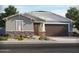 Charming single-story home featuring stone accents, a two-car garage, and professionally landscaped front yard at 24448 W Grenadine Rd, Buckeye, AZ 85326
