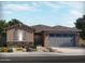 Charming single-story home with a neutral color scheme, gray shutters, and an attached two-car garage at 24478 W Grenadine Rd, Buckeye, AZ 85326