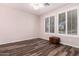 Bedroom featuring wood floors, two windows with wood shutters and a wooden chest at 25633 N 71St Dr, Peoria, AZ 85383