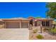 Charming home featuring a tile roof, three-car garage, and professionally landscaped desert-style yard at 25633 N 71St Dr, Peoria, AZ 85383