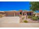 Charming home featuring a tile roof, three-car garage, and professionally landscaped desert-style yard at 25633 N 71St Dr, Peoria, AZ 85383