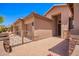 A gated courtyard leads to the entrance of this home with a three-car garage and neutral color scheme at 25633 N 71St Dr, Peoria, AZ 85383