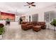 Inviting living room featuring a leather sectional sofa, ceiling fan, and open view to the kitchen at 25633 N 71St Dr, Peoria, AZ 85383