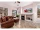 Comfortable living room with a stone fireplace, tile floors, and large windows for natural light at 25633 N 71St Dr, Peoria, AZ 85383
