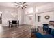 Open-concept living room featuring dark wood floors, a chandelier and lots of natural light at 25633 N 71St Dr, Peoria, AZ 85383