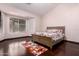 Comfortable main bedroom with hardwood floors, a floral bedspread, and natural lighting at 25633 N 71St Dr, Peoria, AZ 85383
