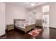 Serene main bedroom showcasing hardwood floors, floral bedding, and ensuite access at 25633 N 71St Dr, Peoria, AZ 85383