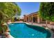 Backyard pool view with lush landscaping, covered patio and blue sky above at 25633 N 71St Dr, Peoria, AZ 85383