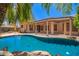 Backyard pool with lush landscaping, covered patio and blue sky in the background at 25633 N 71St Dr, Peoria, AZ 85383