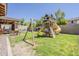 Well maintained backyard with a playhouse set with a yellow slide and swing set at 3173 N Clanton St, Buckeye, AZ 85396
