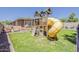 Wonderful backyard featuring a playhouse set with a yellow slide and swing set at 3173 N Clanton St, Buckeye, AZ 85396