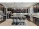 Well-equipped kitchen with a large center island, stainless appliances, and dark cabinetry at 3173 N Clanton St, Buckeye, AZ 85396