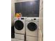 Efficient laundry room featuring a front load washer, dryer, and dark cabinets for storage at 3211 W Pollack St, Phoenix, AZ 85041
