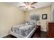 Inviting bedroom with ceiling fan, window with blinds, and a small side table at 4043 E Carla Vista Dr, Gilbert, AZ 85295